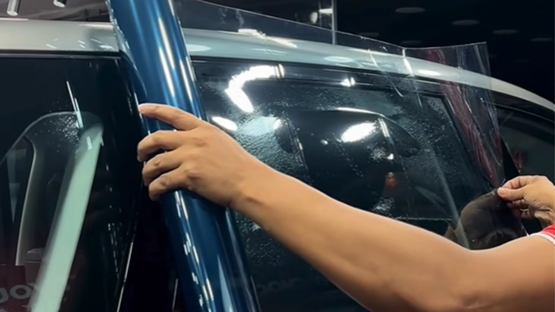 Car sun film installation on vehicle window in Hyderabad