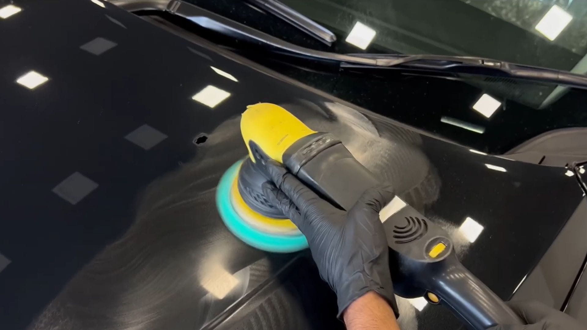 Technician machine polishing a car during paint correction