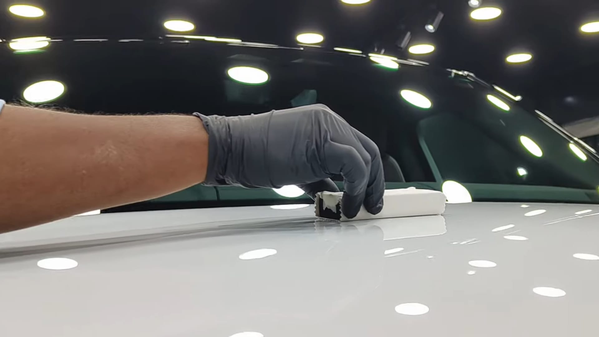 Technician applying ceramic coating to car paint