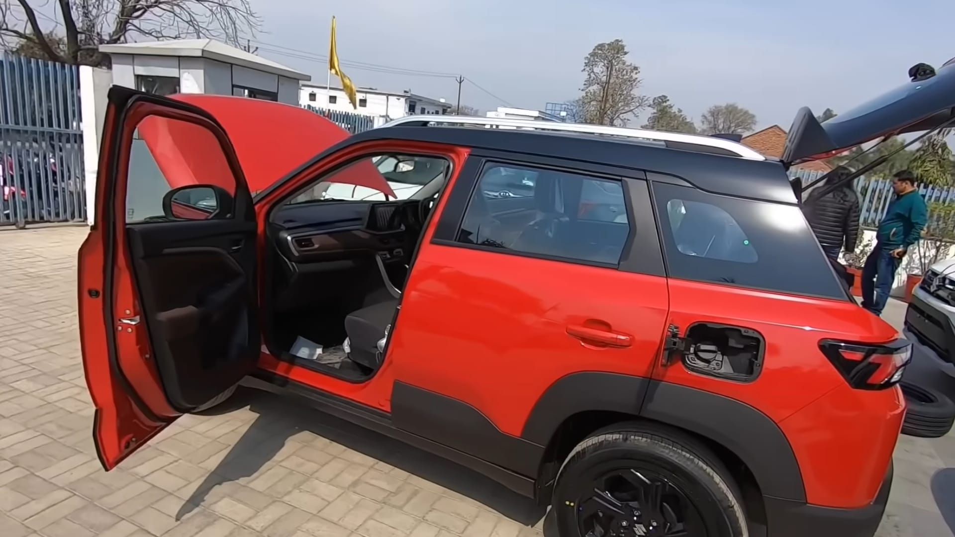 Technician performing a pre-delivery inspection on a new car